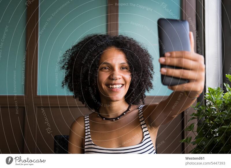Happy young woman taking selfie in a coffee shop portrait portraits Selfie Selfies females women Adults grown-ups grownups adult people persons human being