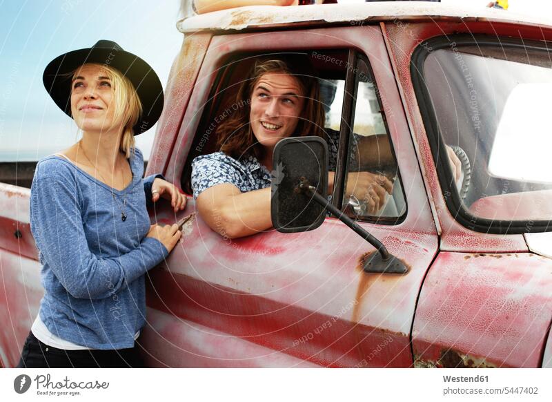 Smiling young couple with an old pick up Pick Up transport vehicles twosomes partnership couples smiling smile Pickup Truck van Cargo Vans motor vehicle