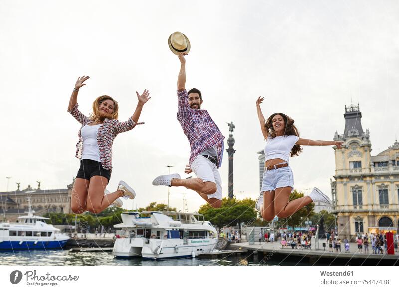 Spain, Barcelona, three friends jumping in the city center near the sea mate Leaping happiness happy Fun having fun funny friendship jumps waterfront