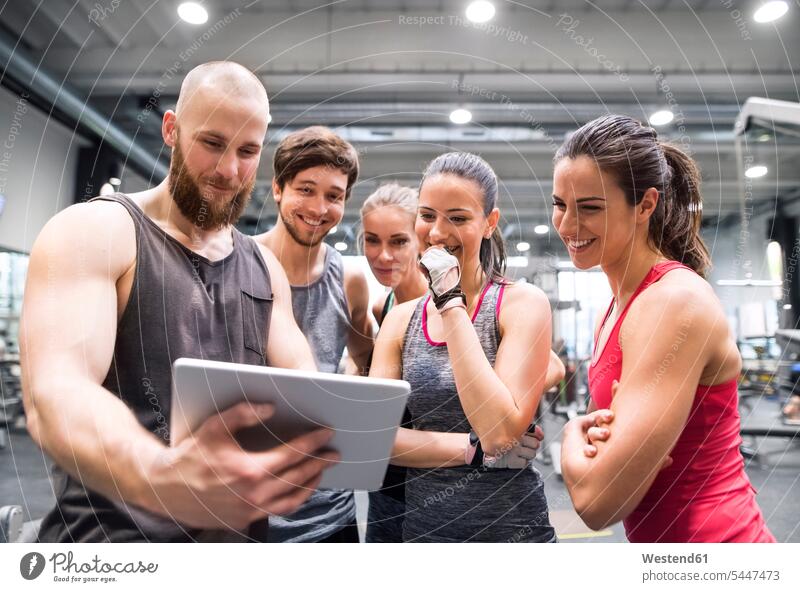 Group of happy athletes with tablet after exercising in gym gyms Health Club looking eyeing smiling smile digitizer Tablet Computer Tablet PC Tablet Computers