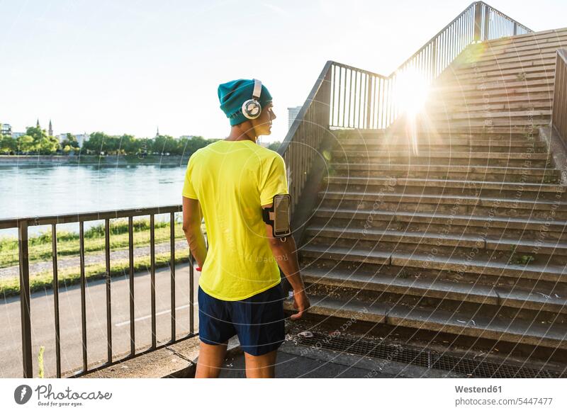 Young athlete jogging up stairs in the city headphones headset stairway bridge bridges Sportspeople Sportsman Sportsperson athletes Sportsmen fit running jogger