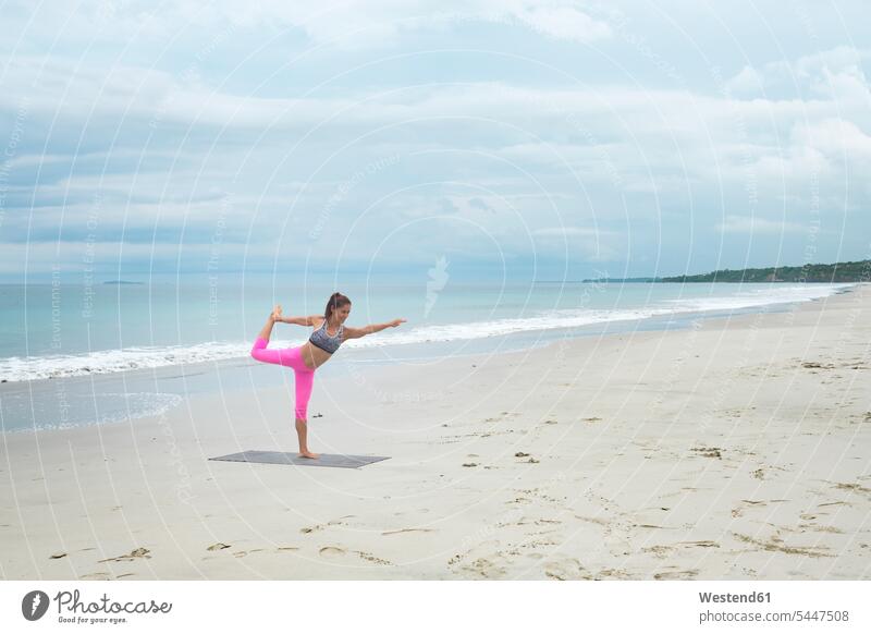 Woman practicing yoga on the beach fit woman females women sportive sporting sporty athletic beaches practice practise exercise exercising practising