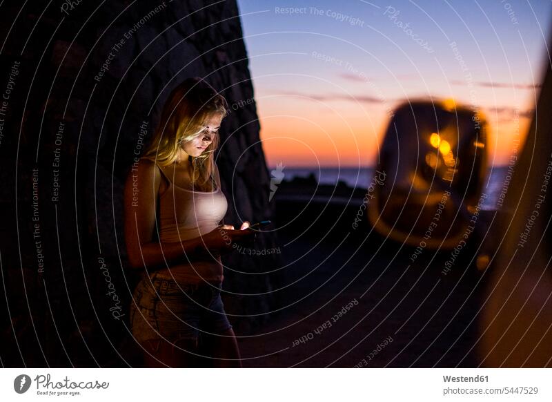 Woman using cell phone at sunset use Smartphone iPhone Smartphones woman females women sea ocean Camper sunsets sundown mobile phone mobiles mobile phones