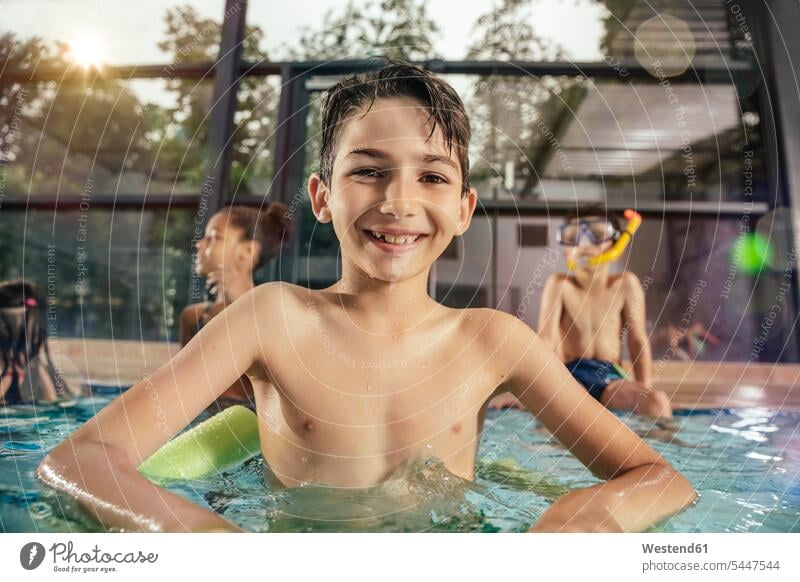 Portrait of smiling boy with friends in indoor swimming pool swimming bath boys males portrait portraits indoor swimming pools smile child children kid kids
