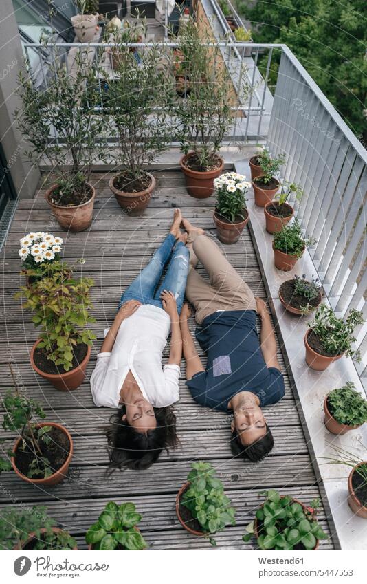 Relaxed couple lying on balcony balconies relaxed relaxation laying down lie lying down twosomes partnership couples relaxing people persons human being humans
