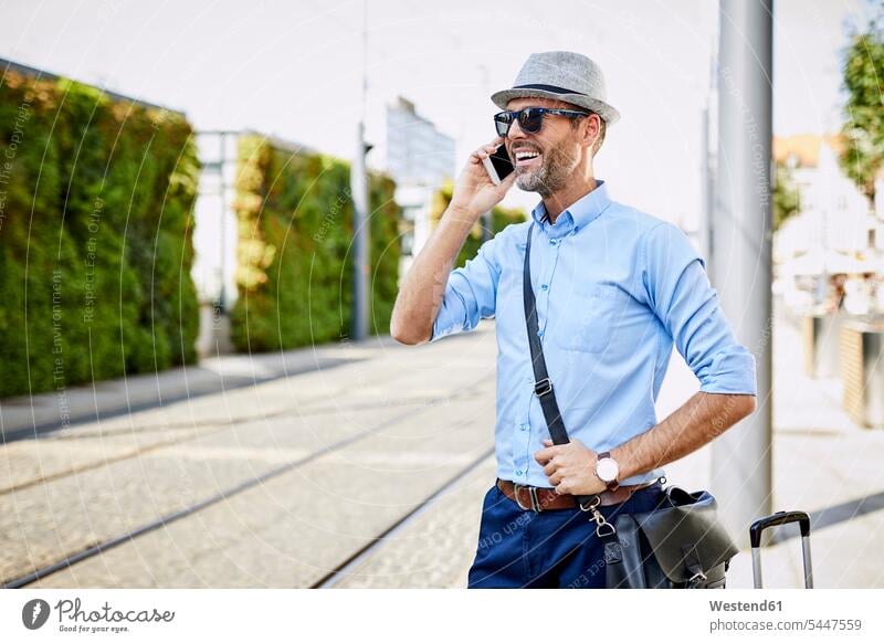 Traveler in the city on the phone call telephoning On The Telephone calling smiling smile mobile phone mobiles mobile phones Cellphone cell phone cell phones