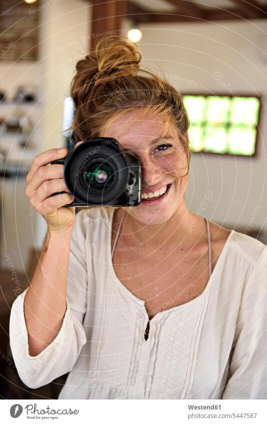 Portrait of laughing young woman taking picture with camera females women portrait portraits cameras photographing Adults grown-ups grownups adult people
