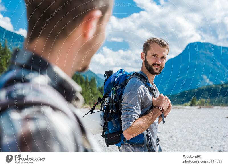 Germany, Bavaria, portrait of young hiker with backpack looking at his friend friends portraits wanderers hikers friendship hiking eyeing brother brothers