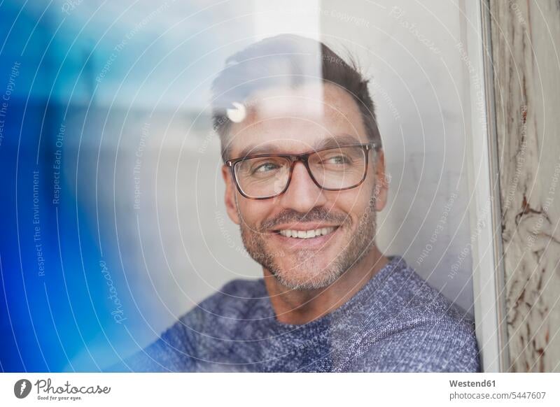 Portrait of smiling man behind glass pane wearing glasses relaxed relaxation specs Eye Glasses spectacles Eyeglasses portrait portraits glass panes men males