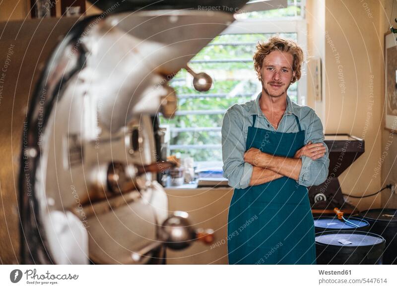 Portrait of confident coffee roaster in his shop smiling smile man men males portrait portraits retail trade trading Adults grown-ups grownups adult people