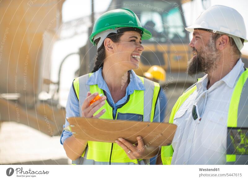 Male and female quarry workers discussing on site gravel pit blue collar worker blue-collar worker mining working At Work discussion checking Test testing Check
