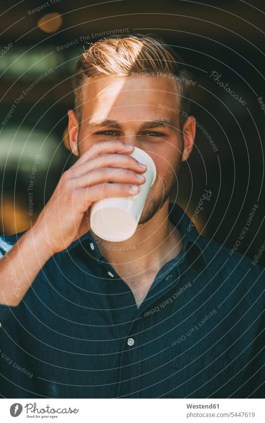Portrait of young man with coffee to go drinking men males portrait portraits Adults grown-ups grownups adult people persons human being humans human beings