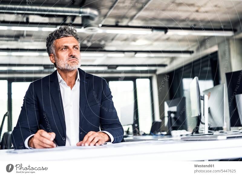 Mature businessman in office thinking offices office room office rooms Businessman Business man Businessmen Business men workplace work place place of work