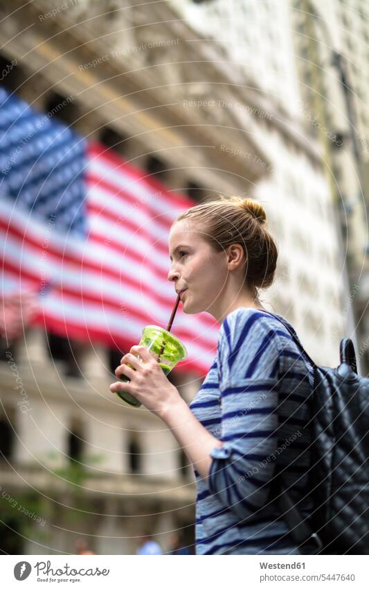 USA, New York City, woman drinking a smoothie in front of New York Stock Exchange Smoothies females women Drink beverages Drinks Beverage food and drink