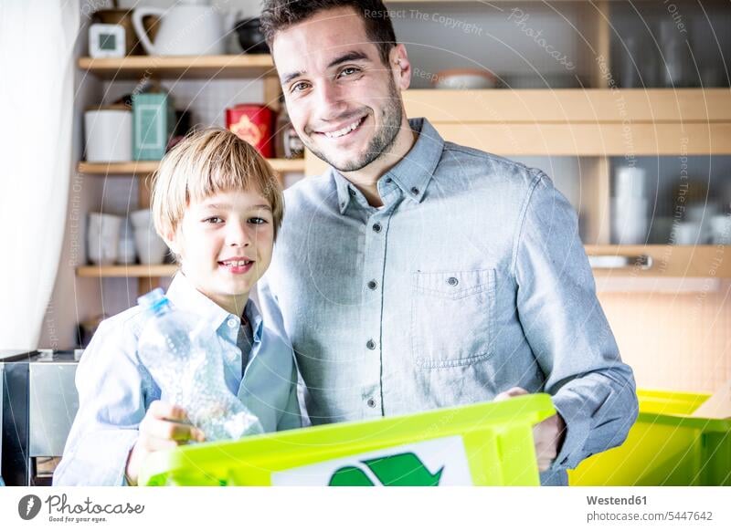 Father and son at home with waste box sons manchild manchildren Rubbish recycling ecology recycle smiling smile family families father pa fathers daddy dads