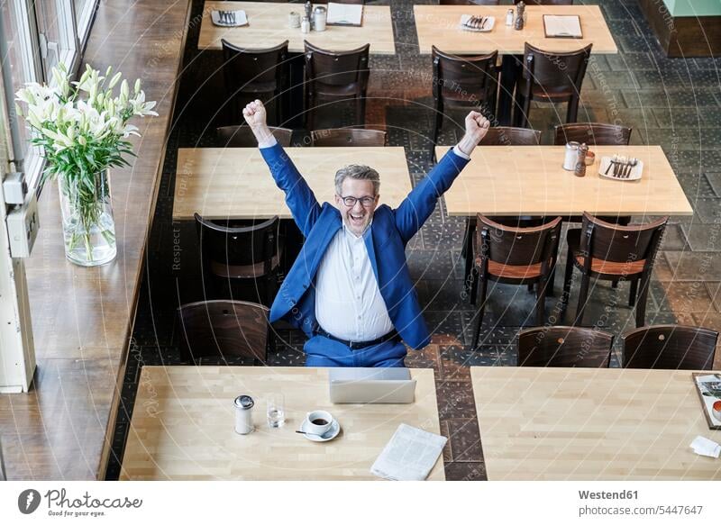 Cheering mature businessman in cafe with laptop Businessman Business man Businessmen Business men happiness happy working At Work business people businesspeople