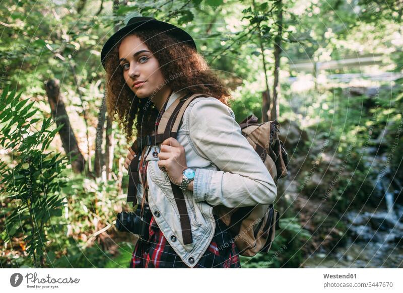 Portrait of teenage girl with backpack and camera in nature portrait portraits forest woods forests Teenage Girls female teenagers Teenager Teens people persons
