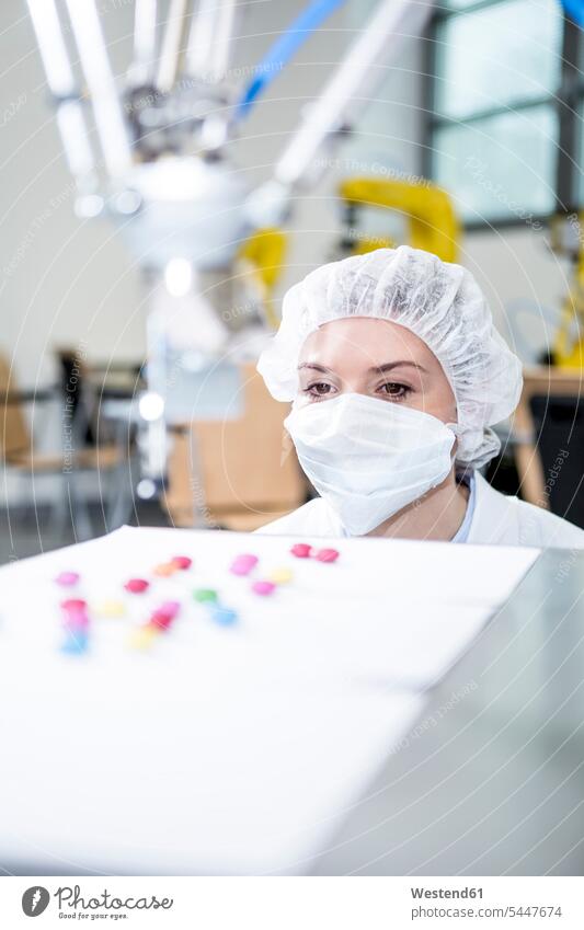 Woman watching robot handling sweets Sweets Candies Sweet Food factory factories woman females women Robot foods food and drink Nutrition Alimentation