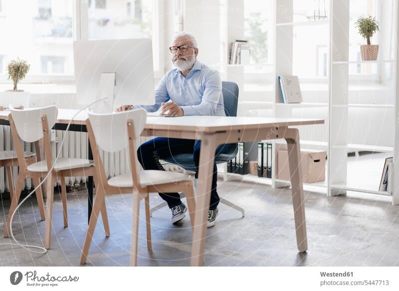 Mature man with beard and glasses working at desk men males At Work Adults grown-ups grownups adult people persons human being humans human beings Businessman