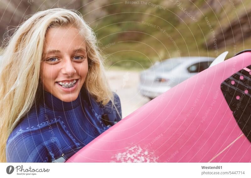 Spain, Aviles, portrait of smiling young surfer on the beach surfboard surfboards portraits beaches Teenage Girls female teenagers smile female surfer surfers