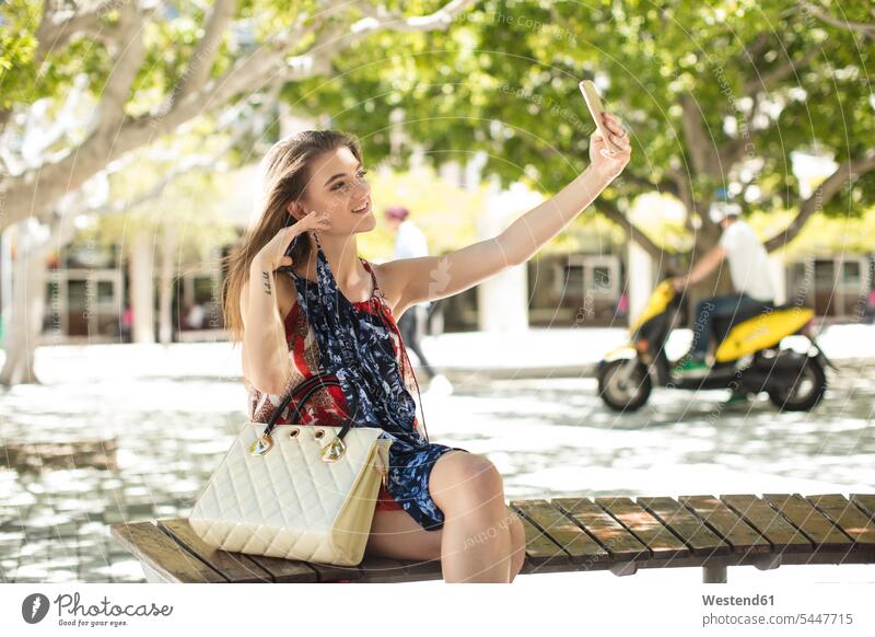 Fashionable woman taking a selfie in the city happiness happy mobile phone mobiles mobile phones Cellphone cell phone cell phones smiling smile Selfie Selfies
