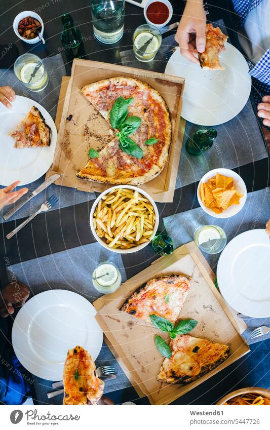 Friends having pizza and French fries hand human hand hands human hands friends Table Tables eating Pizza Pizzas people persons human being humans human beings