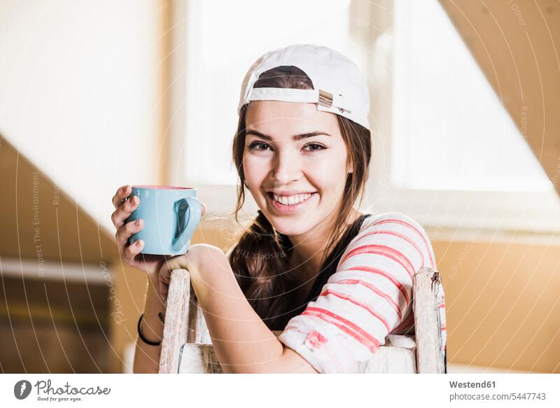 Young woman on construction site holding cup of coffee DIY Doityourself Do it yourself Do-it-yourself young women young woman home ownership private owned home