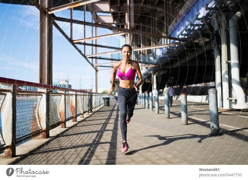 Woman training in the morning in Manhattan near Brooklyn Bridge exercising exercise practising running woman females women bridge bridges fast quick speediness