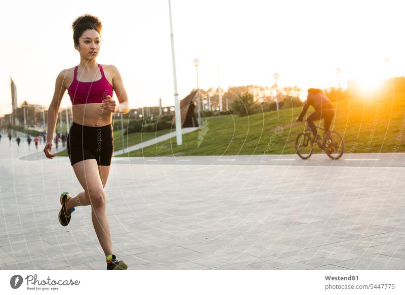 Young woman jogging at evening twilight Jogging females women jogger joggers female jogger fitness sport sports Adults grown-ups grownups adult people persons