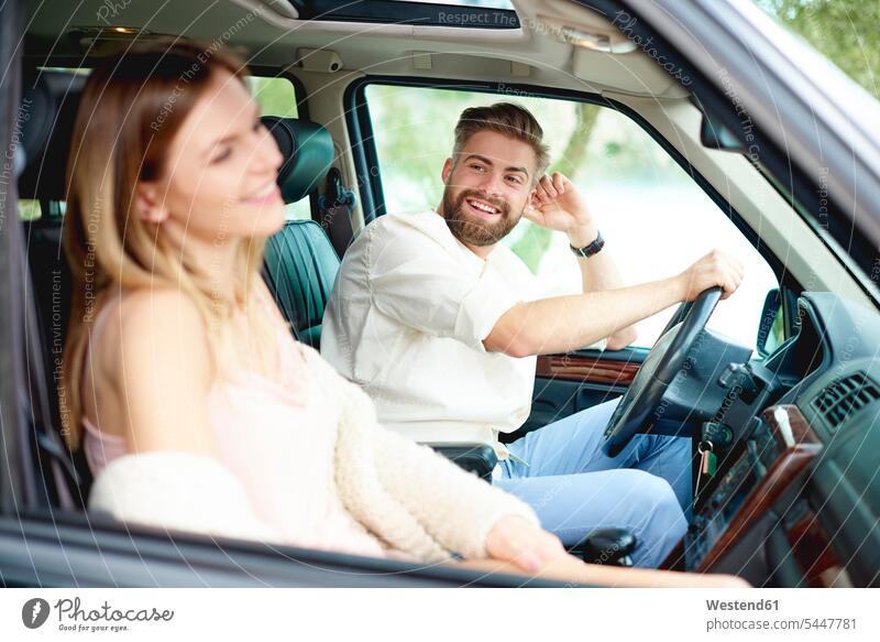Happy young couple in car automobile Auto cars motorcars Automobiles looking eyeing happiness happy twosomes partnership couples smiling smile motor vehicle