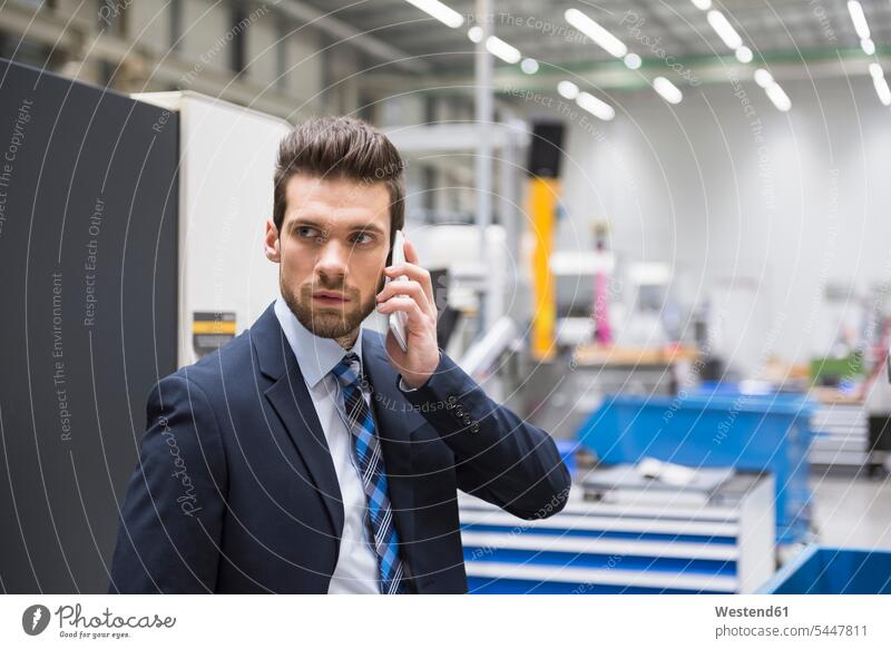 Businessman in factory shop floor on the phone call telephoning On The Telephone calling mobile phone mobiles mobile phones Cellphone cell phone cell phones