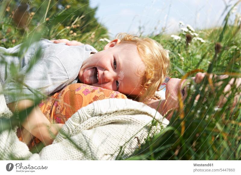 Happy mother and son lying in meadow child children happiness happy relaxed relaxation laying down lie lying down mommy mothers ma mummy mama meadows family