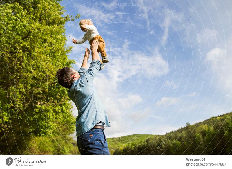 Father throwing baby in the air infants nurselings babies father pa fathers daddy dads papa Fun having fun funny people persons human being humans human beings