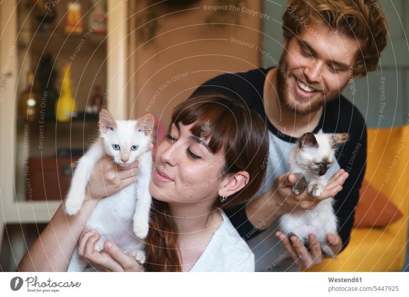 Young couple with kittens at home twosomes partnership couples cat cats people persons human being humans human beings pets animal creatures animals holding
