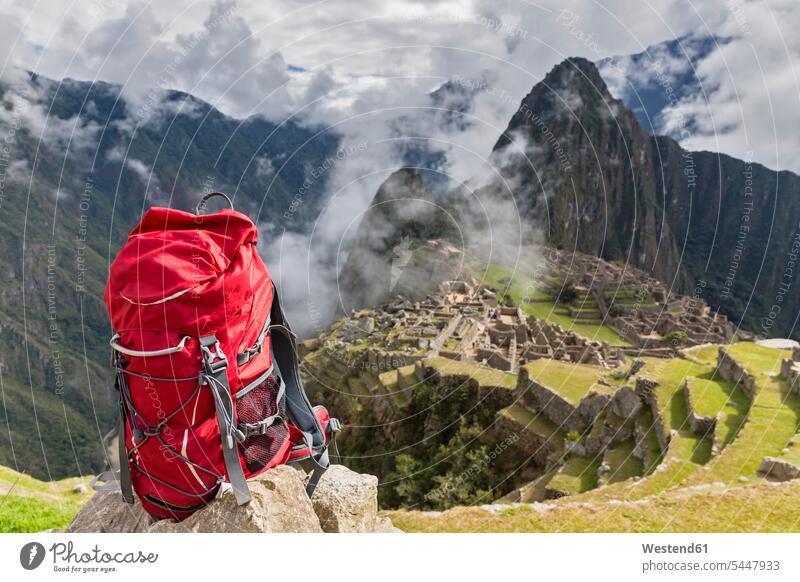 Peru, Andes, Urubamba Valley, red backpack at Machu Picchu with mountain Huayna Picchu rock rocks Activity active Freedom Liberty free Exploration exploring