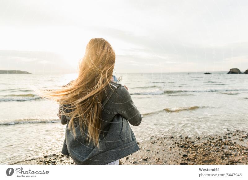 Young woman watching the sunset on the beach sunsets sundown females women beaches relaxed relaxation atmosphere atmospheric mood moody Atmospheric Mood Vibe
