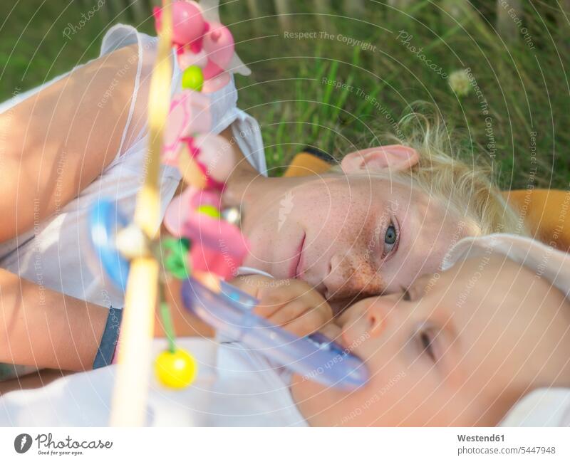 Freckled girl lying with baby girl on blanket on a meadow females girls portrait portraits child children kid kids people persons human being humans
