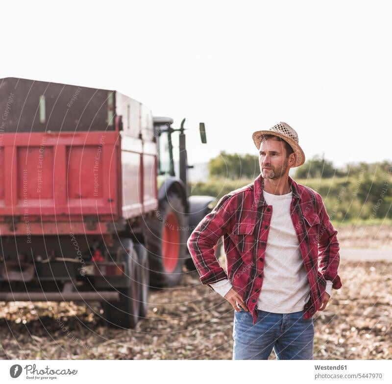Farmer standing on field farmer agriculturists farmers man men males Field Fields farmland agriculture Adults grown-ups grownups adult people persons