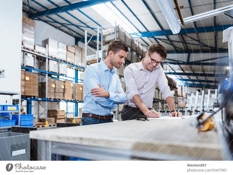 Business people standing on shop floor, discussing product improvement Meeting Meetings Business Meeting discussion business people businesspeople