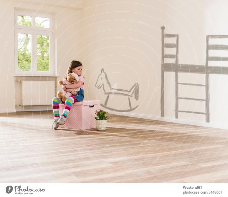 Girl in empty apartment sitting on a box holding teddy girl females girls teddies child children kid kids people persons human being humans human beings