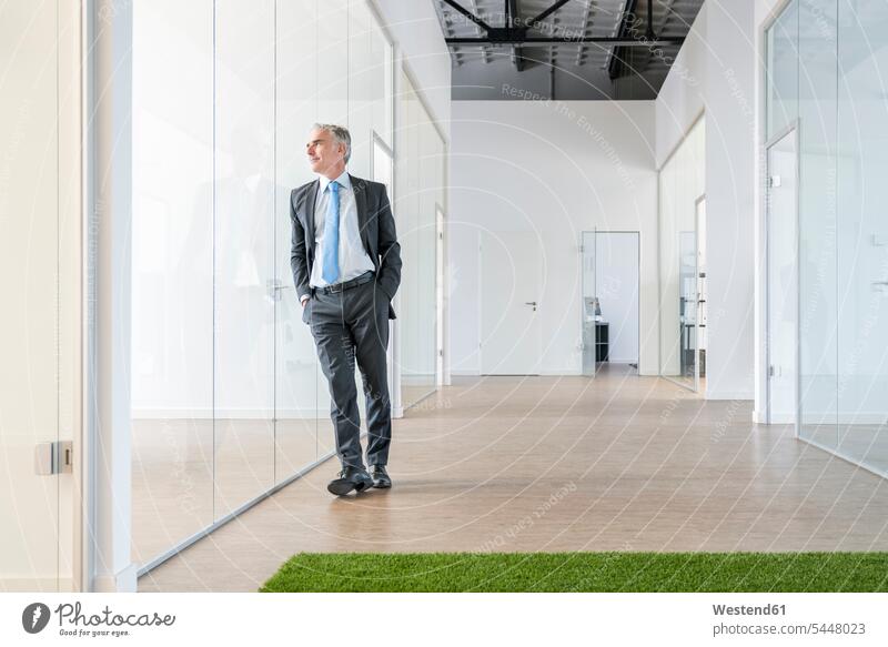 Mature businessman standing in office space with green grass carpet sharing share offices office room office rooms Green Business Coworking space