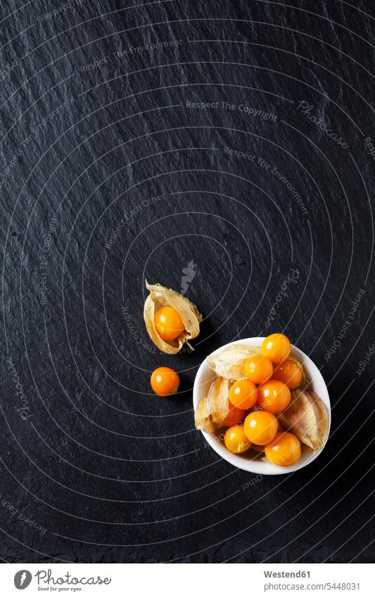 Bowl of Physalis on slate food and drink Nutrition Alimentation Food and Drinks close-up close up closeups close ups close-ups orange Bowls Cape gooseberry