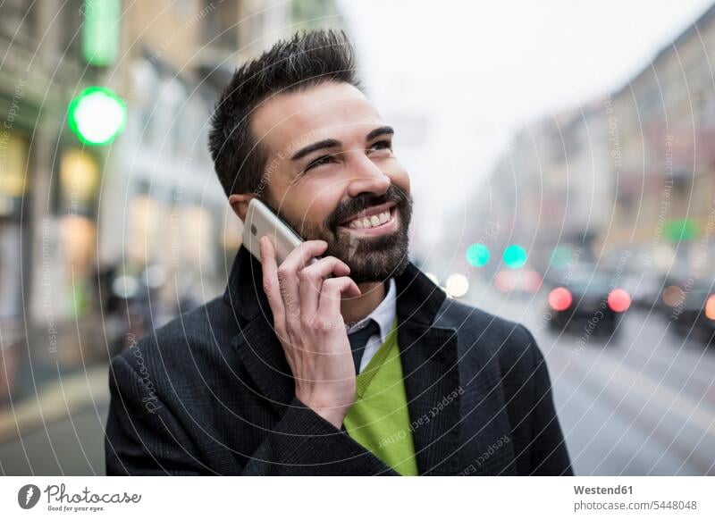 Smiling businessman in the city on cell phone Businessman Business man Businessmen Business men town cities towns on the phone call telephoning On The Telephone