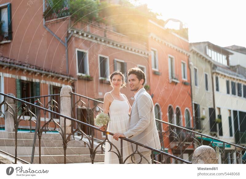 Italy, Venice, bridal couple standing on stairs at sunrise twosomes partnership couples bridal couples people persons human being humans human beings