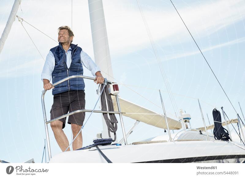 Portrait of smiling mature man on his sailing boat looking at distance men males Adults grown-ups grownups adult people persons human being humans human beings