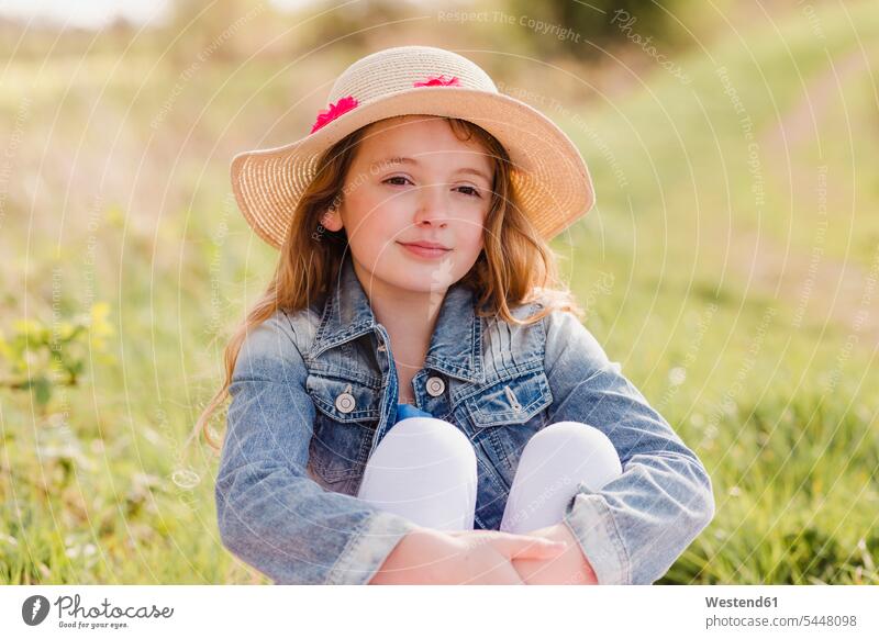 Portrait of girl wearing straw hat sitting on a meadow females girls portrait portraits meadows child children kid kids people persons human being humans