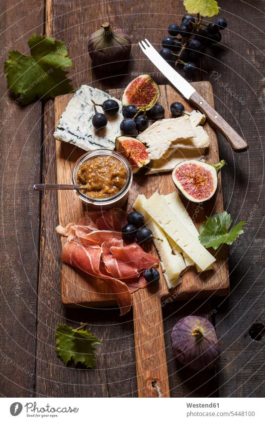Cheese platter with fruits and fig mustard food and drink Nutrition Alimentation Food and Drinks dark wood Ham Fruit Fruits knife knives blue grape red grape