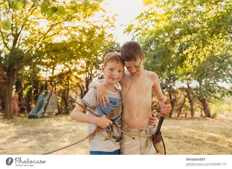 Boys playing with bow and arrows boy boys males friends Archery Bows bows child children kid kids people persons human being humans human beings friendship