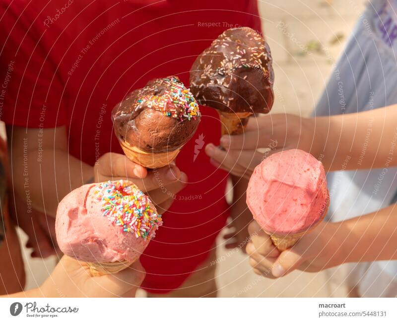 Eating ice cream together. Children holding waffles with ice cream together - closeup Ice iceesse ball bearing Ice cream nascheb at the same time Waffle