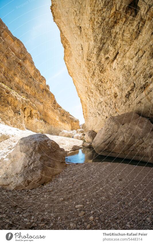 Stream between high rocks Wadi Nature Sand Dry Vacation & Travel clear water River Water Tourism Swimming & Bathing popular Oman Cliff Canyon Sky Colour photo